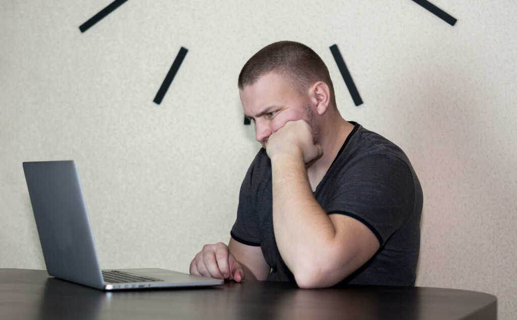 frustrated web user - man looking frustrated staring at his laptop